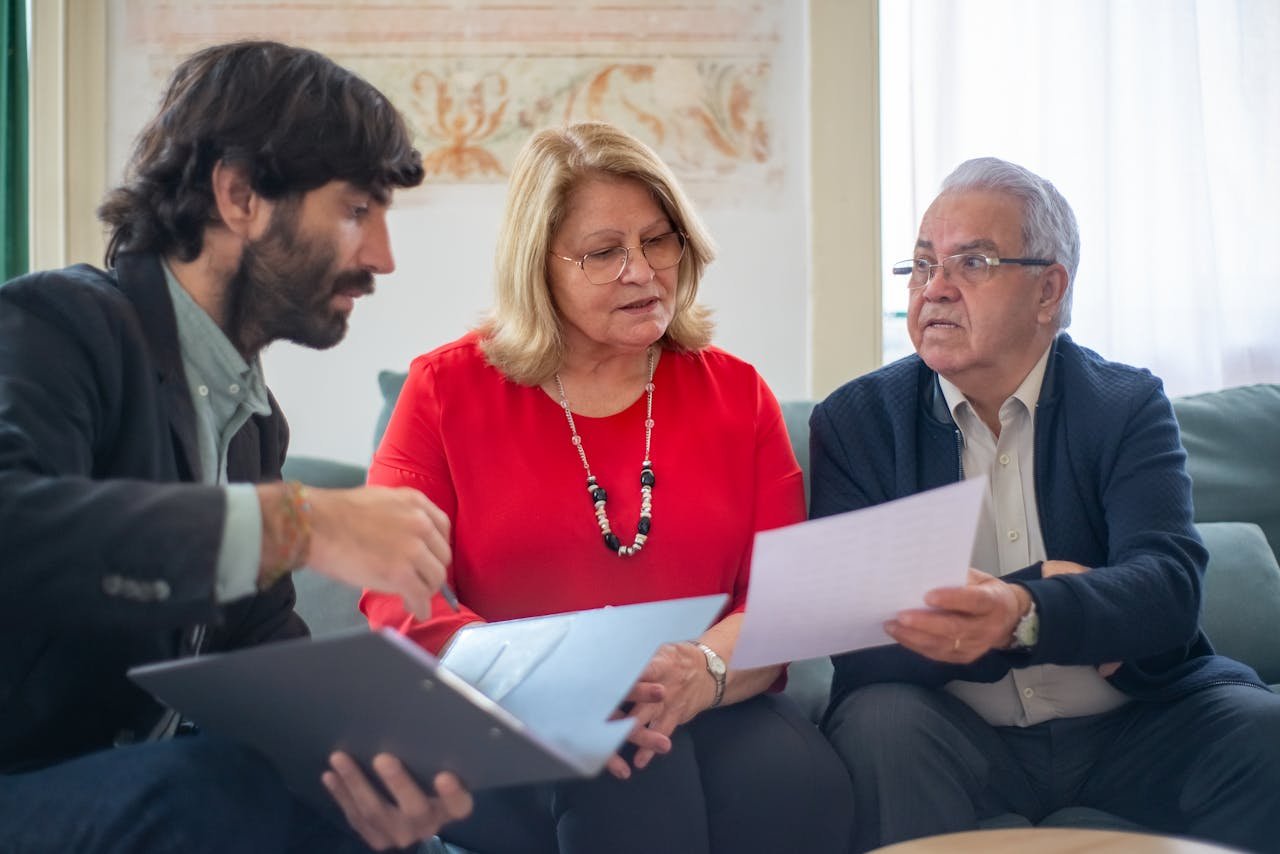 Home Senior couple consulting with a professional advisor, discussing documents indoors.