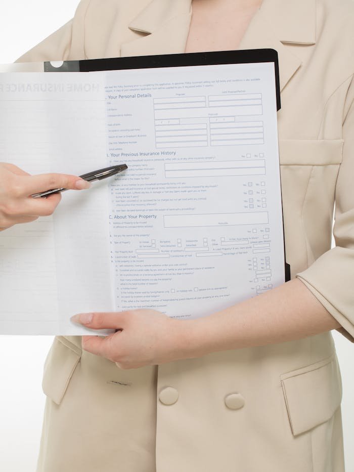 About Close-up of a professional presenting insurance paperwork with a pen.